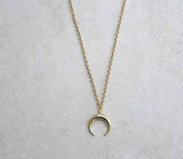 This crescent moon necklace is part of the Talisman Alchemy collection (long, level three length), gold-plated, and worn with a 36” gold-finished steel curb chain. Completed with a lobster claw clasp and chain end. Stone approximately 3/4 inch; will vary in size. Necklaces within the Talisman Alchemy section are designed to be easily layered with a second and third piece for a completed look that is both beautifully unique and magical. The crescent moon (or lunula in ancient Roman culture) is an iconic shape that calls upon the spirit of the goddess for energy and feminine powers. Traditionally worn by Roman girls, the crescent moon was utilized as protection against evil forces, demons, and sorcery.